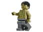 Olivově zelená Lego figurka s černými vlasy a šedými kalhotami, s nakreslenými svaly.