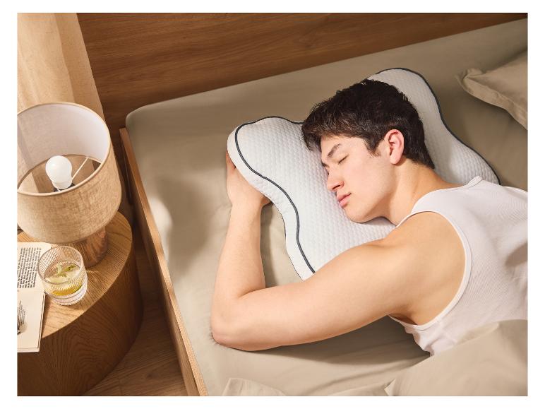 Muž klidně spí na ergonomickém polštáři.