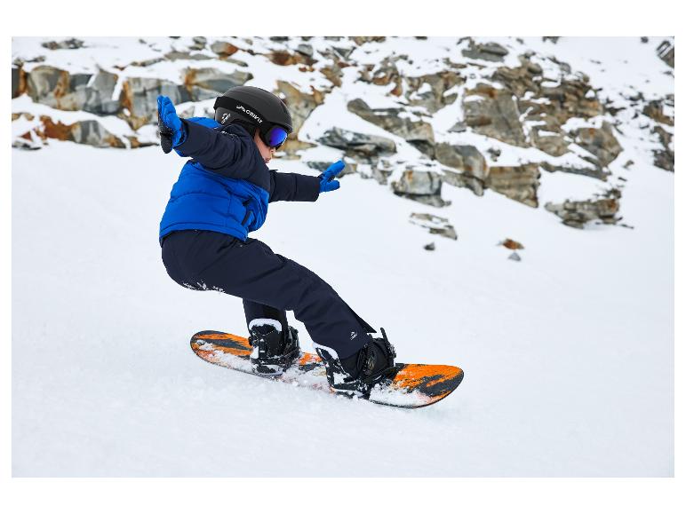 Dítě snowboardista nosí helmu Crivit, brýle a modrou bundu.