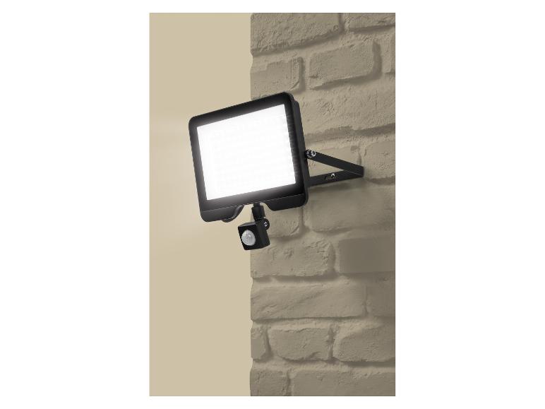 LED venkovní lampa s pohybovým senzorem na béžové cihlové zdi.