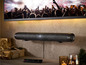 Soundbar s dálkovým ovládáním pod televizorem s koncertem.