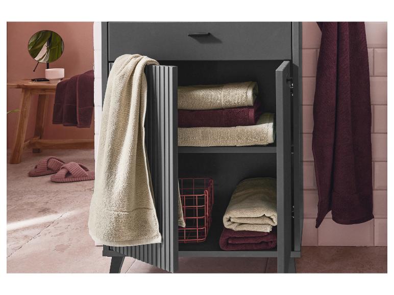 Tmavě šedá koupelnová skříňka s ručníky a doplňky.