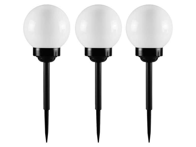 Tři černé zahradní lampy s bílými kulovitými světly.