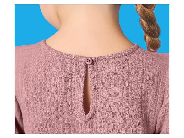 Zadní strana růžové dětské halenky s knoflíkem u krku a copem