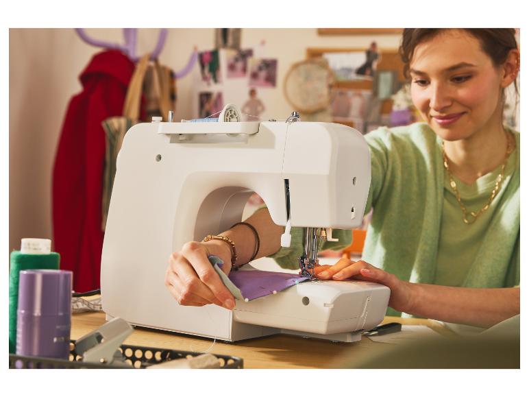 Žena šije na bílém šicím stroji.