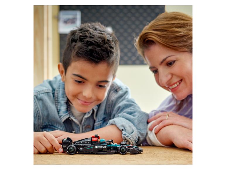Dítě a matka si hrají s modelem závodního auta LEGO Mercedes-AMG Petronas Formula One™ Team.