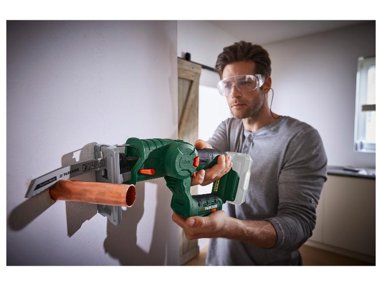 Muž používá reciproční pilu Parkside k řezání měděné trubky.