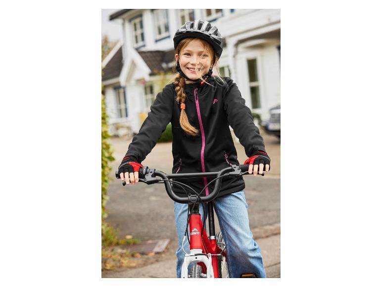 Usmívající se dívka s helmou a cyklistickými rukavicemi, na červeném kole Crivit.