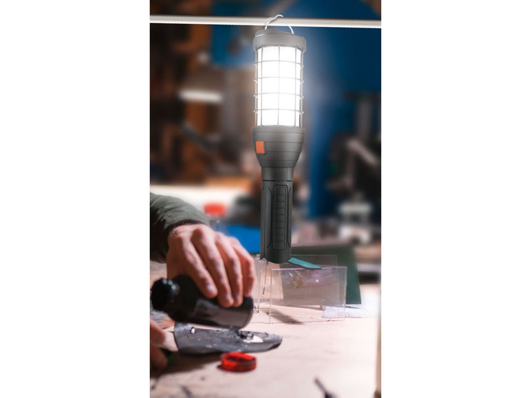 Pracovní lampa s ochranným krytem nad pracovním stolem.