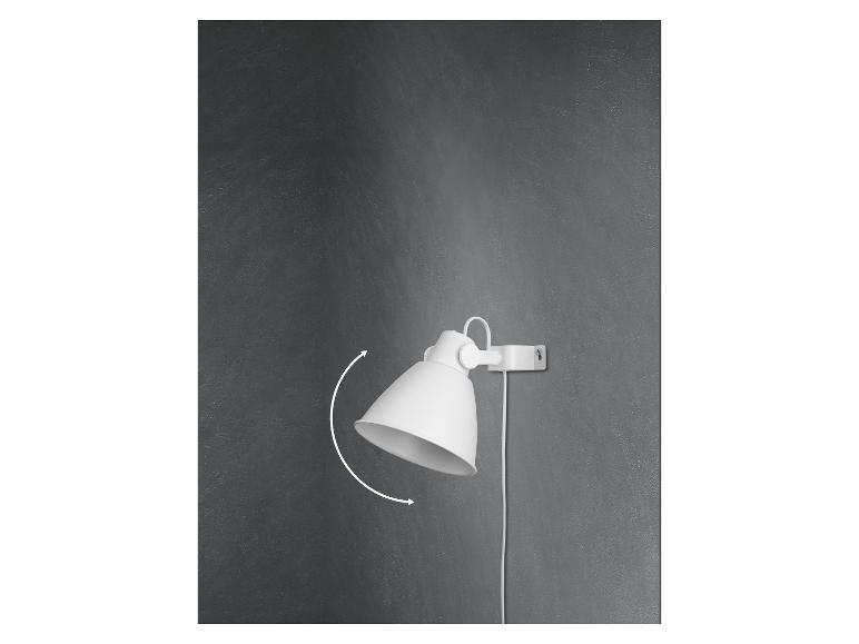 Bílá otočná nástěnná lampa na šedé zdi.
