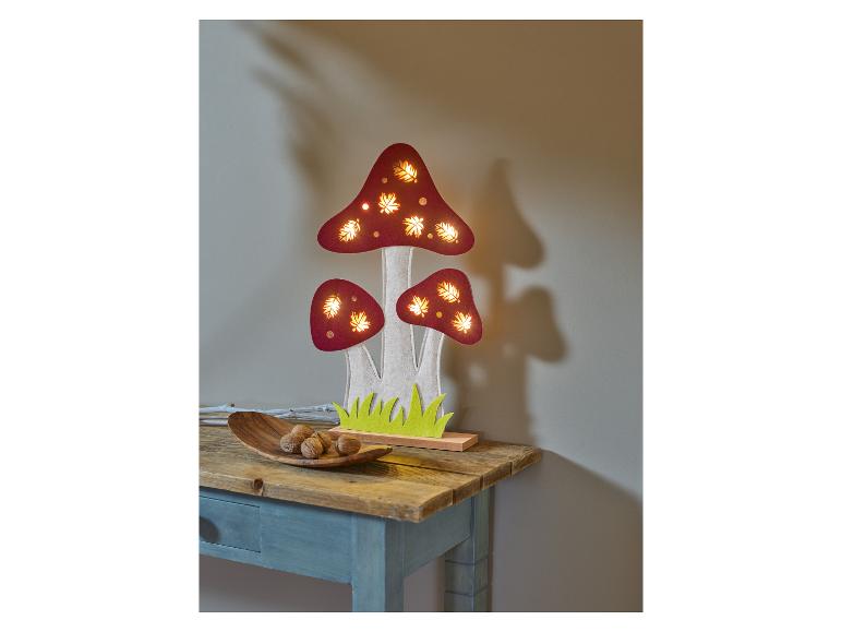 Dřevěná lampa ve tvaru hub s LED diodami na stole.