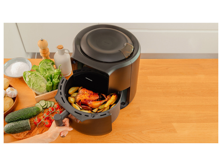 Černý fritovací hrnec Cecotec s pečeným kuřecím a hranolky.