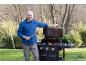 Muž připravuje grilování venku s grilem Grillmeister, masem a zeleninou.