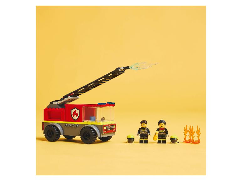 LEGO hasičské auto a minifigurky s doplňky na žlutém pozadí.