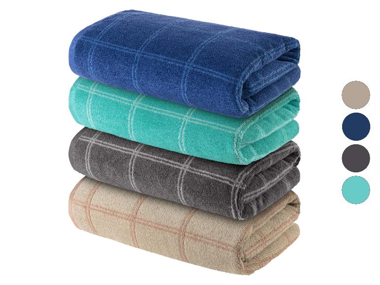 Hromádka koupelnových ručníků v barvách: tmavě modrá, tyrkysová, šedá a béžová.