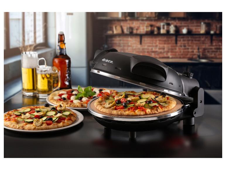 Pizza v pizza peci, dvě pizzy na talířích a pivo na stole.