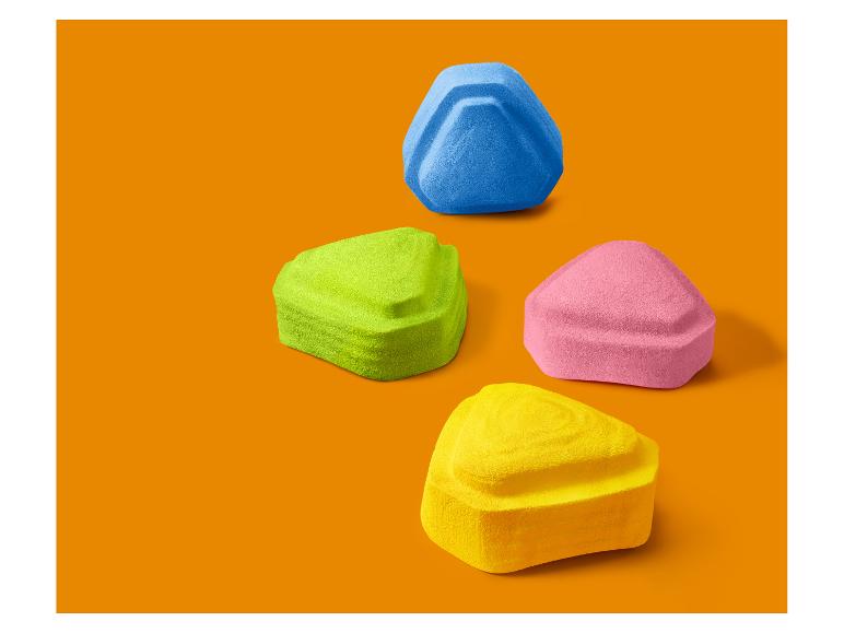 Čtyři barevné trojúhelníkové houbičky na make-up na oranžovém pozadí.