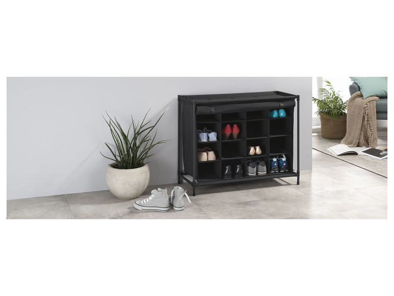 Černá botník s různými druhy obuvi, včetně tenisek a lodiček.