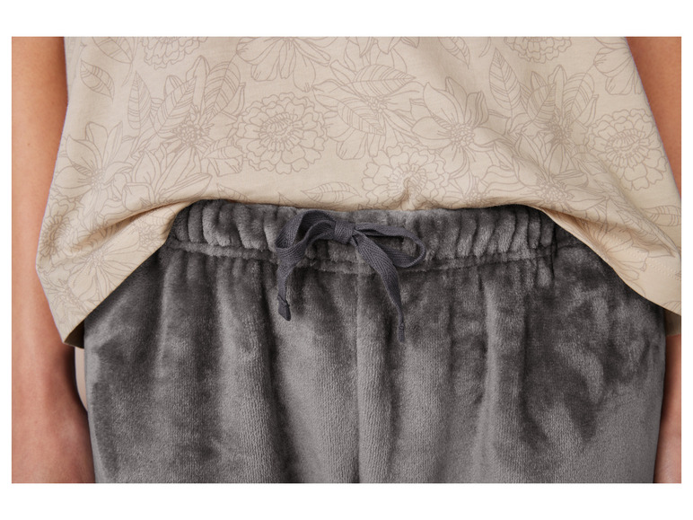 Šedé tepláky s béžovou halenkou s květinovým vzorem.