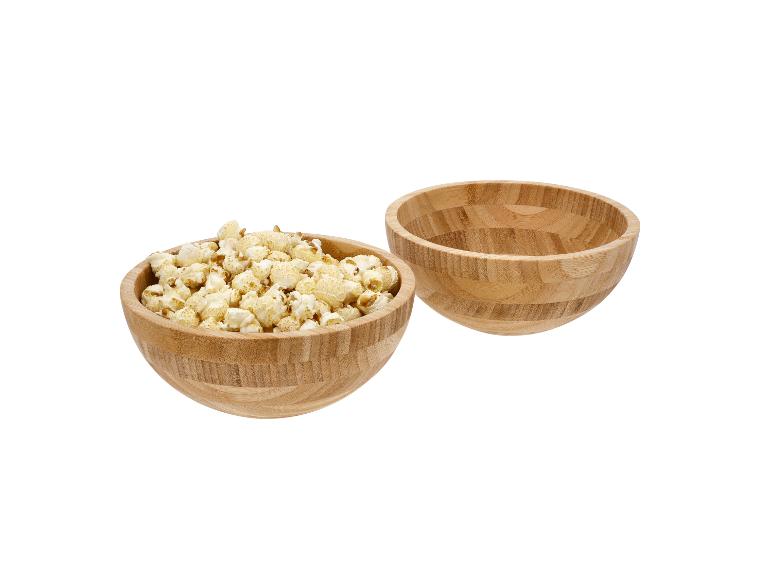 Dvě dřevěné misky, jedna plná popcornu, druhá prázdná.