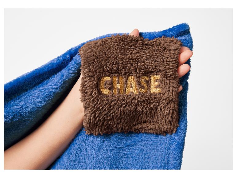 Modrá a hnědá deka s nápisem „CHASE“ v ruce