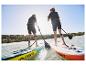 Dvě osoby paddleboardují na nafukovacích prknech Crivit.