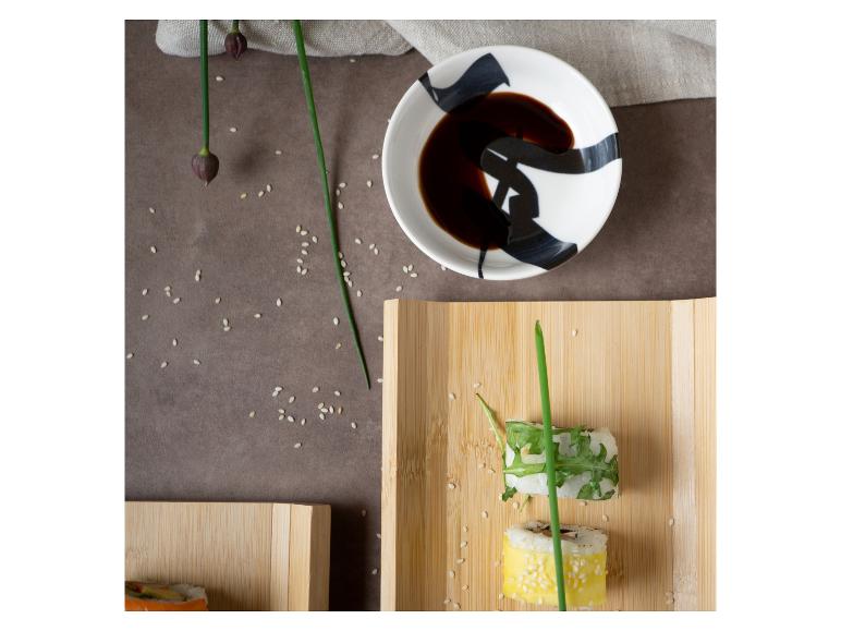 Sushi s avokádem a sezamovými semínky na bambusovém talíři.