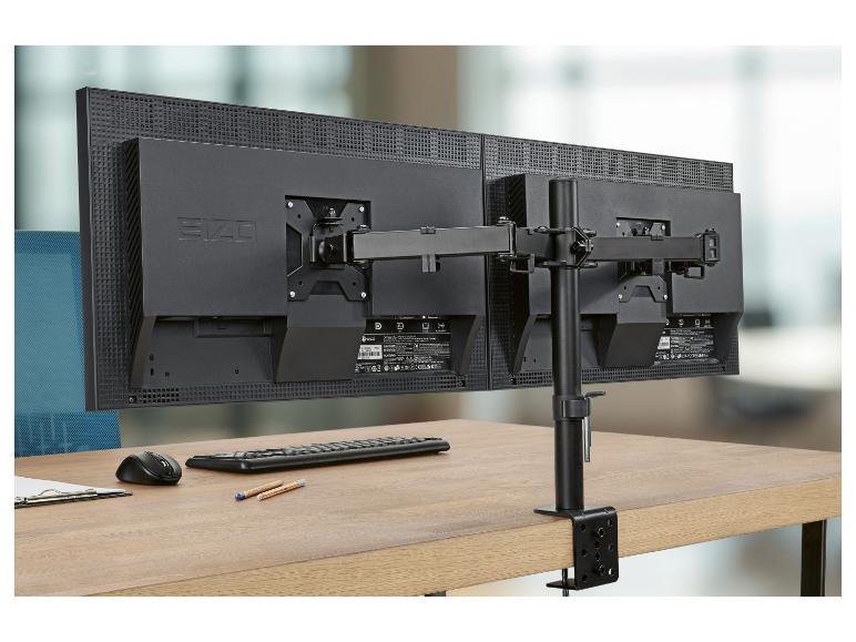 Dva monitory na stole s dvojitým držákem monitoru, klávesnicí, myší a podložkou.