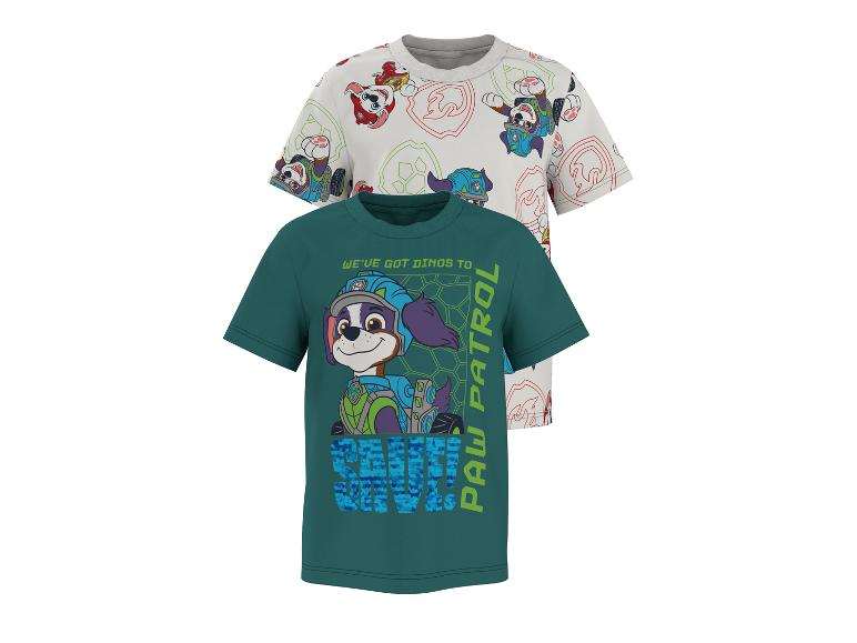 Dvě dětská trička, jedno bílé se vzorem štěňat a druhé zelené se štěnětem a textem 'WE'VE GOT DINOS TO SAVE! PAW PATROL'.