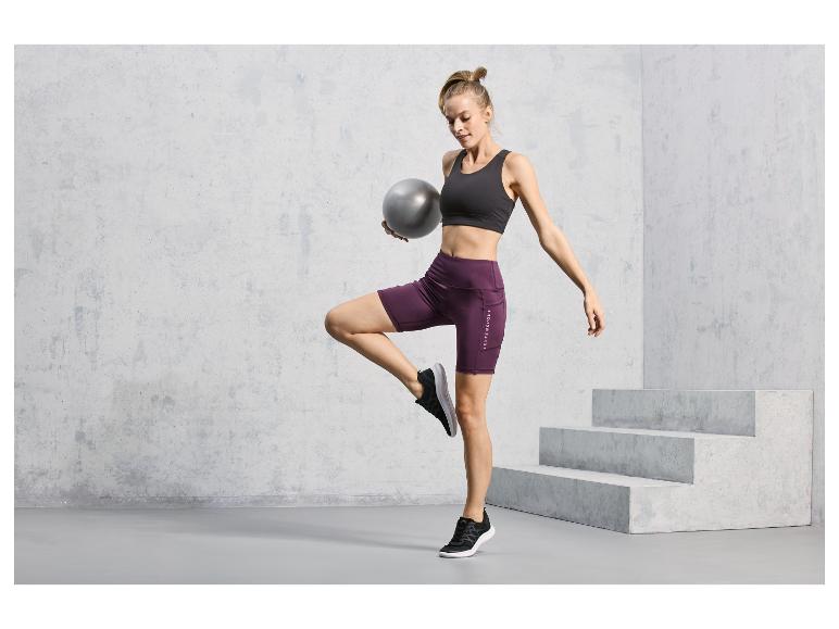 Žena ve sportovním oblečení s Jette Sport šortky a fitness míčem