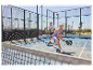 Dvaja hráči padel tenisu na venkovním slunném kurtu.