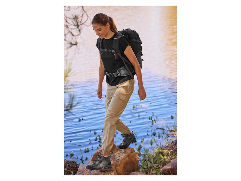 Žena na túře s batohem a turistickými botami.