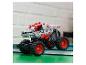 Šedý a červený monster truck LEGO Technic Thunder Roarus na zelených knihách.
