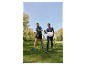 Dva lidé jdou v parku s holemi na nordic walking.