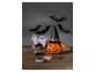 Halloweenské dekorace s dýní, netopýry, duchy a pavouky na dřevěném stole.