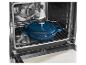 Modrý litinový hrnec v otevřené troubě na roštu.
