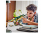 Dítě si hraje s LEGO dinosaurem T-Rex.