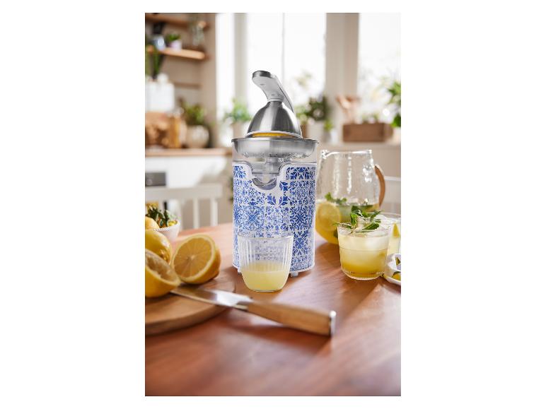 Odšťavňovač, limonáda a citrony na kuchyňském stole.