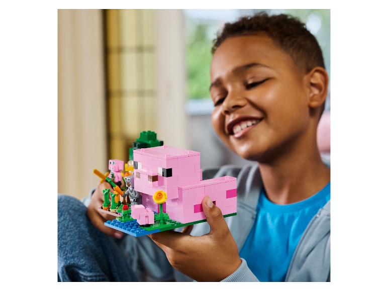 Dítě drží růžové LEGO Minecraft prase.
