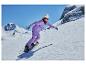 Žena snowboardistka ve fialovém lyžařském obleku na slunném horském svahu.