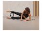 Žena cvičí pilates s kruhem na podložce.