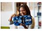 Žena drží modrý model auta LEGO Technic Ford GT s bílými pruhy.