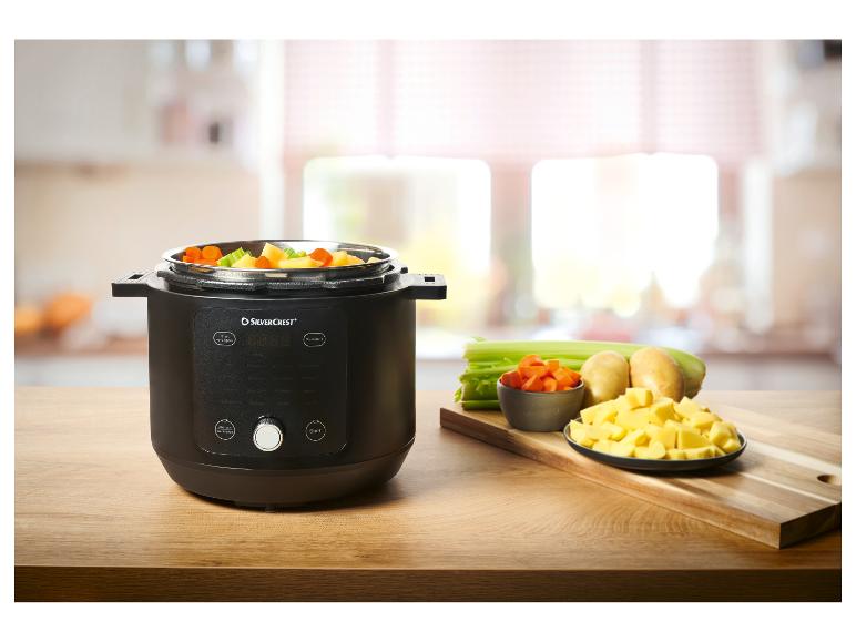 Multifunkční hrnec SilverCrest se zeleninou na dřevěném stole.