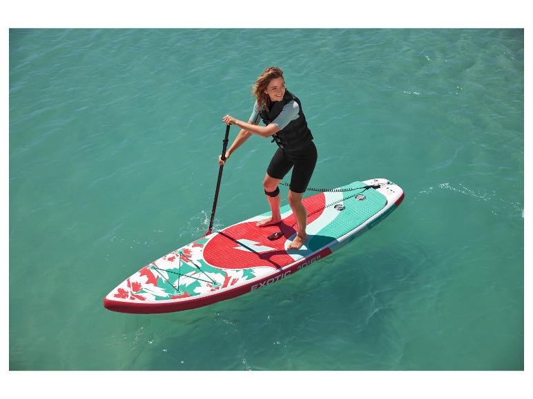 Žena pádluje na nafukovacím paddleboardu Exotic 10'6″ s květinovým vzorem.