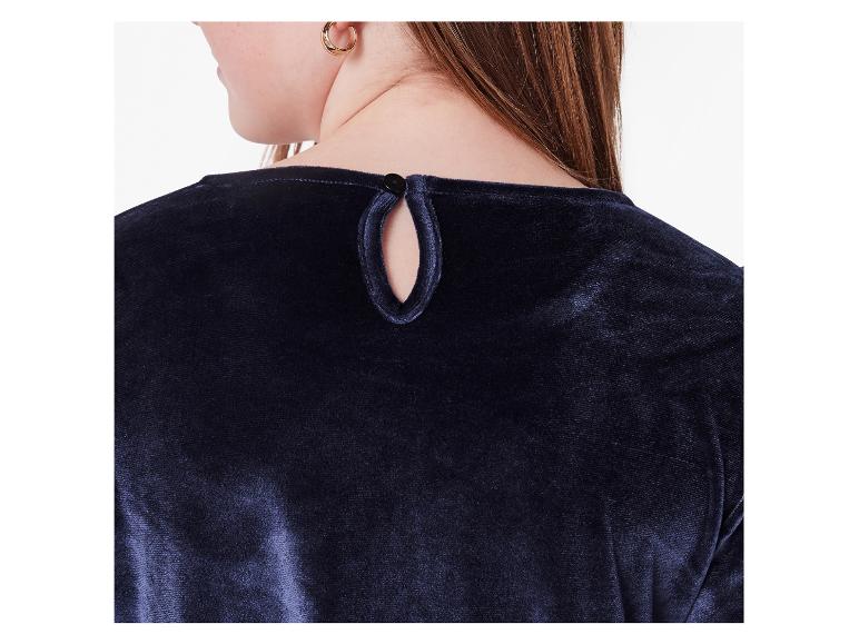 Detailní záběr zezadu na ženu v tmavě modré sametové halence se zapínáním na knoflík u krku.