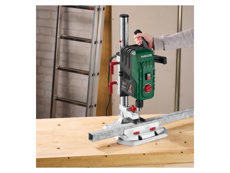 Osoba používá vrtačku Parkside k vrtání kovové tyče na pracovním stole.