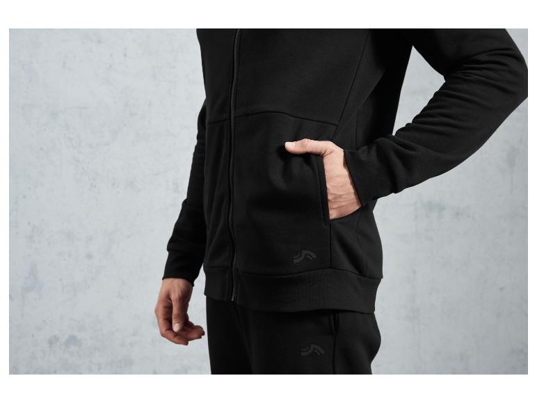 Muž v černé mikině a kalhotách značky 'The North Face'.