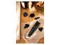 Zastřihovač vlasů s různými nástavci a zastřihovač nosu/uší na ručníku.