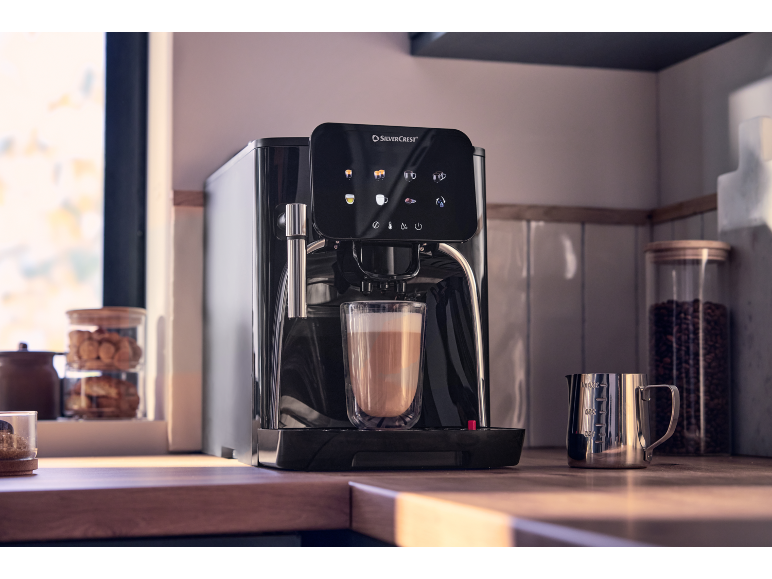 Plně automatický kávovar s šálkem latte na kuchyňské lince.