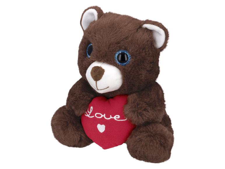Hnědý plyšový medvídek drží červené srdce s nápisem „Love“.